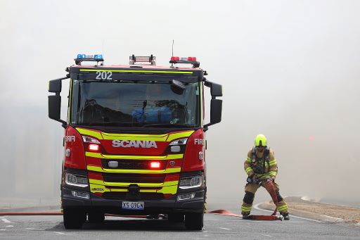 Firefighter and truck standing in smoke.